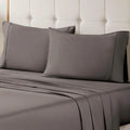 A neatly made bed styled with a gray 700 Thread Count Egyptian Cotton Sateen Bed Sheet Set, featuring smooth flat and fitted sheets alongside matching pillows