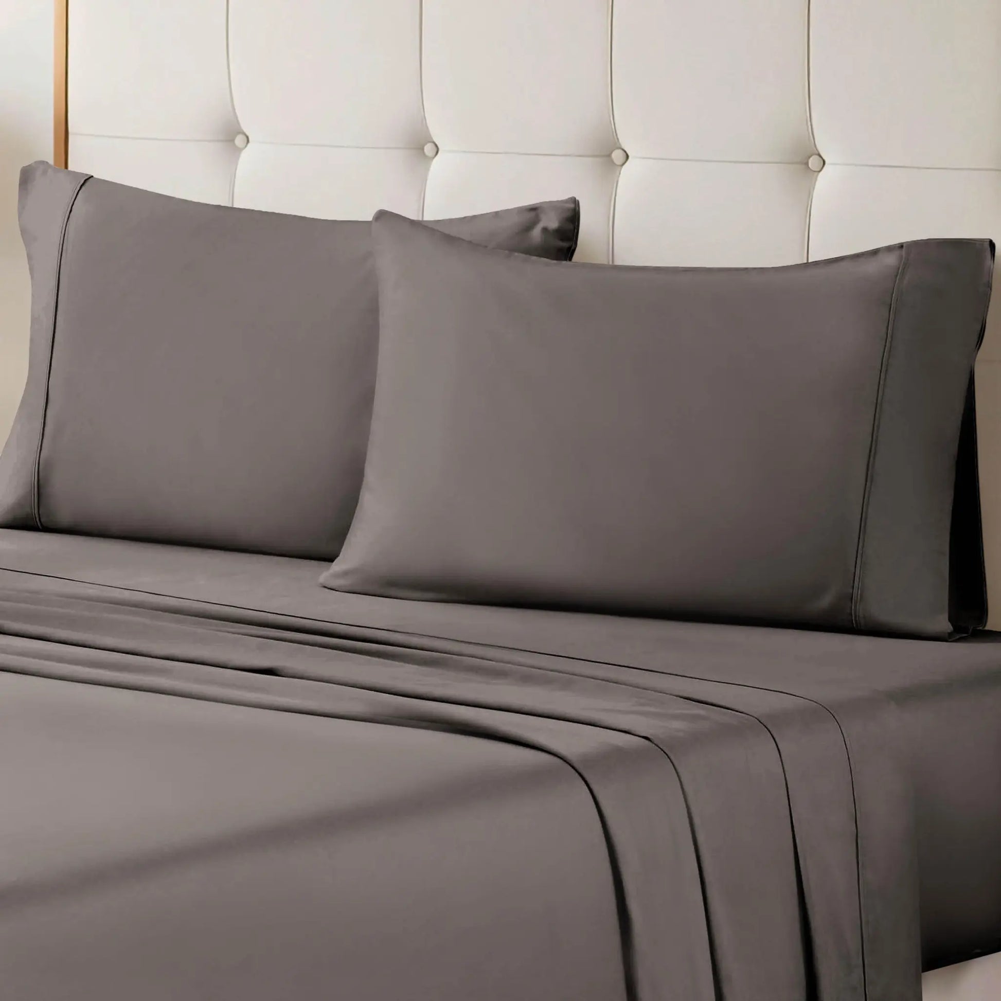 A neatly made bed styled with a gray 700 Thread Count Egyptian Cotton Sateen Bed Sheet Set, featuring smooth flat and fitted sheets alongside matching pillows