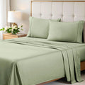 A neatly made bed styled with a sage green 700 Thread Count Egyptian Cotton Sateen Bed Sheet Set, featuring smooth flat and fitted sheets alongside matching pillows