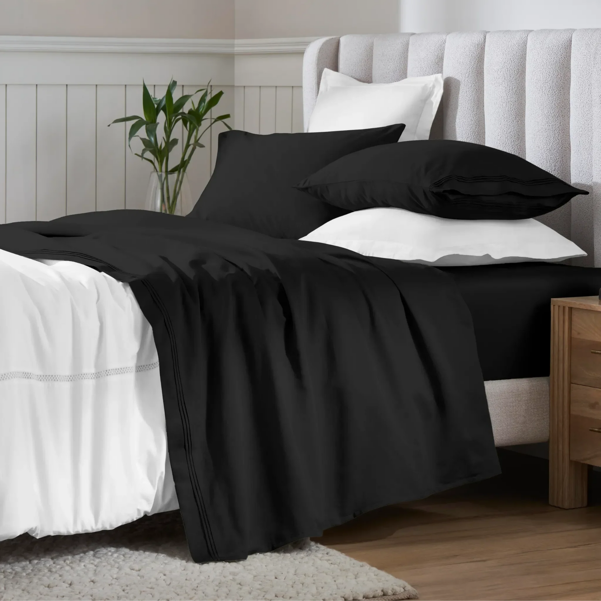 Black 650 thread count Egyptian cotton sateen sheets arranged on a modern bed with coordinating pillows.