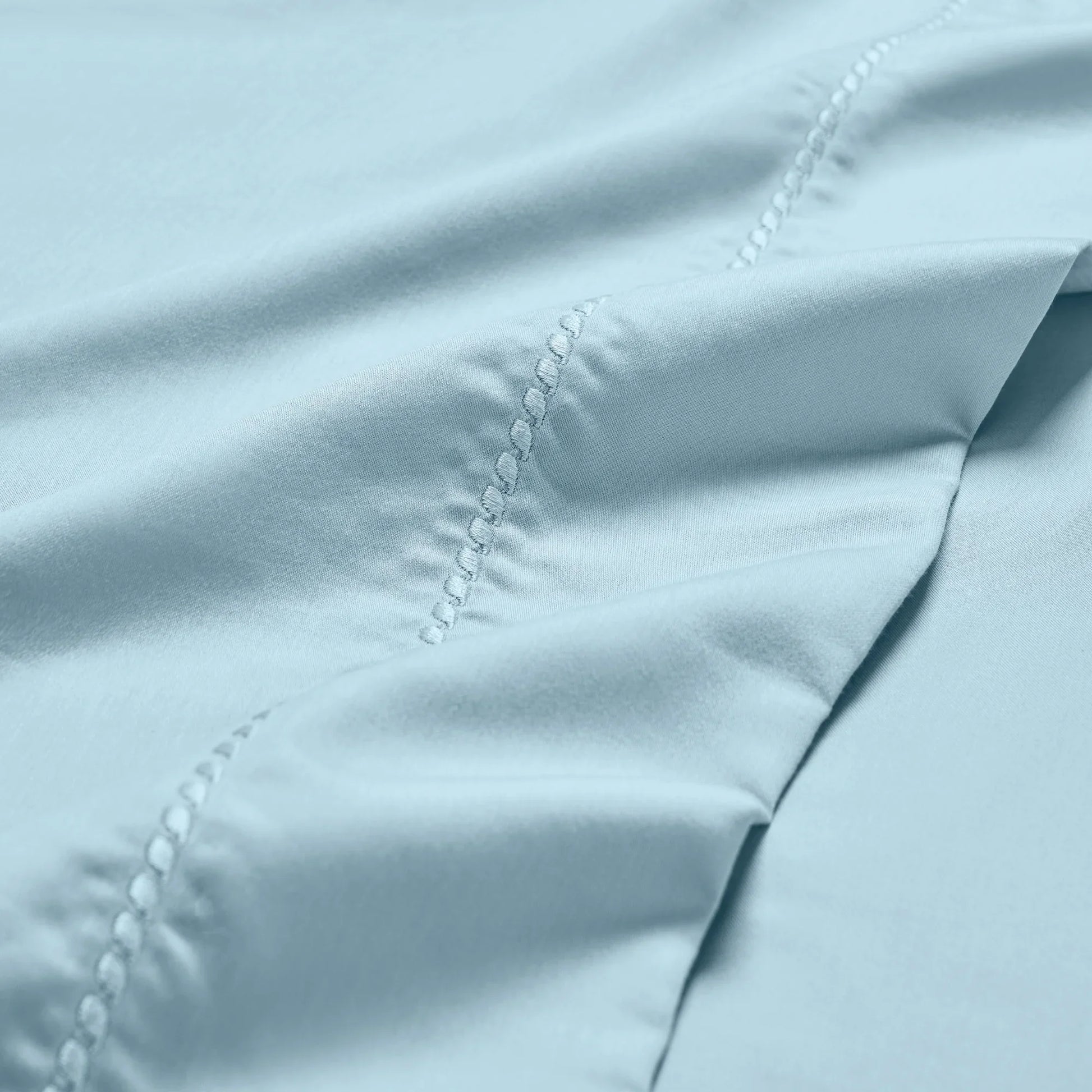 Blue Imperia embroidered hem pillowcase set close-up detail.