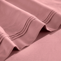 Close-up of Blush pink Egyptian cotton sateen sheet hems with decorative triple-row stitching.