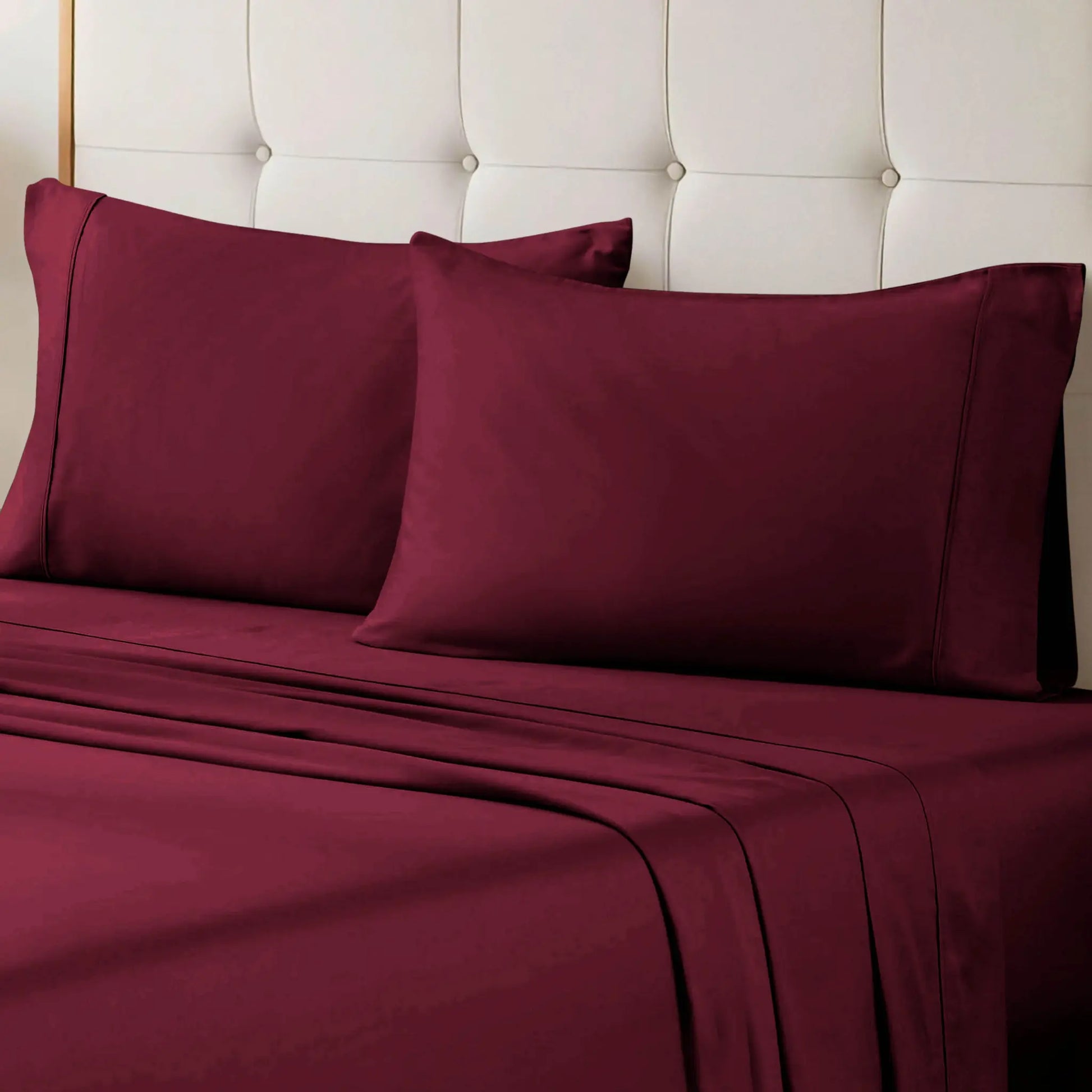 Burgundy 700 Thread Count Egyptian Cotton Sateen Bed Sheet Set displayed on a modern bed