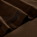 Close-up of Chocolate brown Egyptian cotton sateen sheet hems with decorative triple-row stitching.