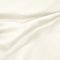 Close-up texture view of smooth, draped ivory 300 thread count modal sheets made from beechwood