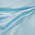 Close-up texture view of smooth, draped light blue 300 thread count modal sheets made from beechwood