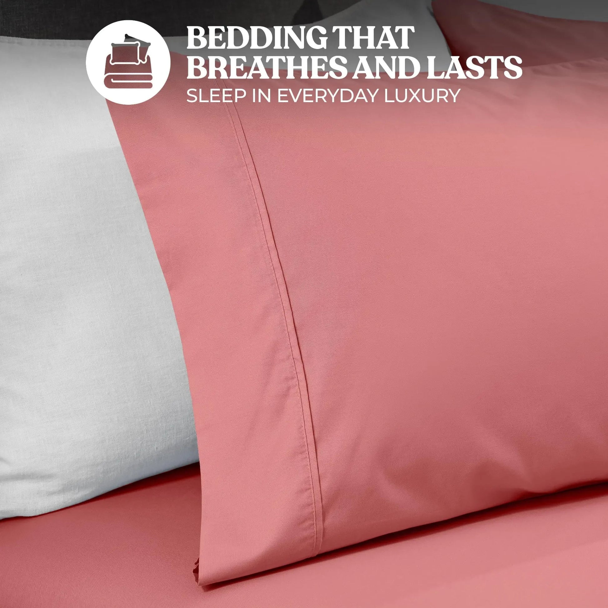 Close-up view of a blush pink cotton blend pillowcase showing stitched hem detailing and fabric texture.