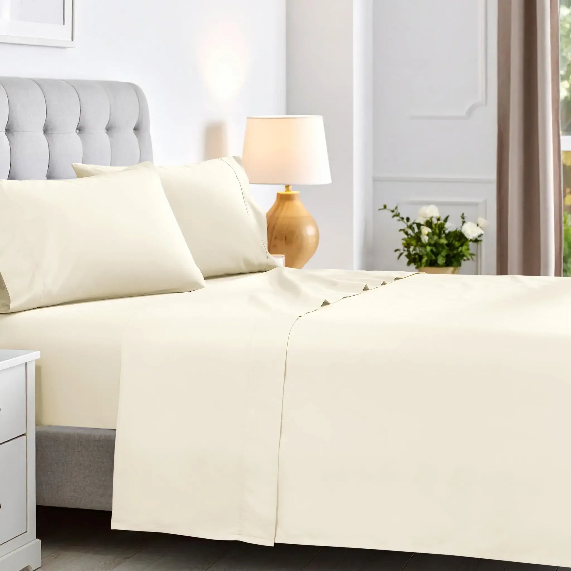 Cream colored 600 thread count cotton blend bed sheet set on a neatly made bed