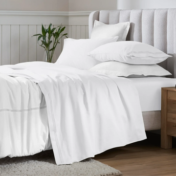 Crisp white Egyptian Cotton Sateen Sheet Set neatly arranged on a bed