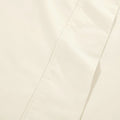 Extreme close-up macro shot of cream cotton blend fabric showing fine weave texture and subtle hem stitching.