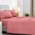 Full bedroom view of a blush pink deep pocket sheet set featuring matching pillowcases and flat sheet