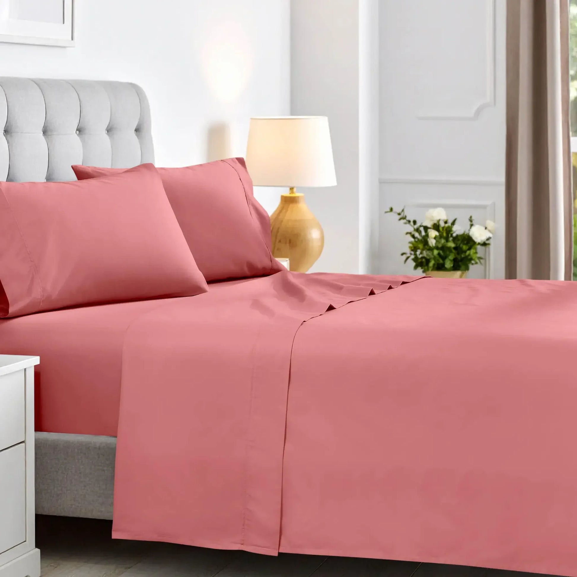 Full bedroom view of a blush pink deep pocket sheet set featuring matching pillowcases and flat sheet