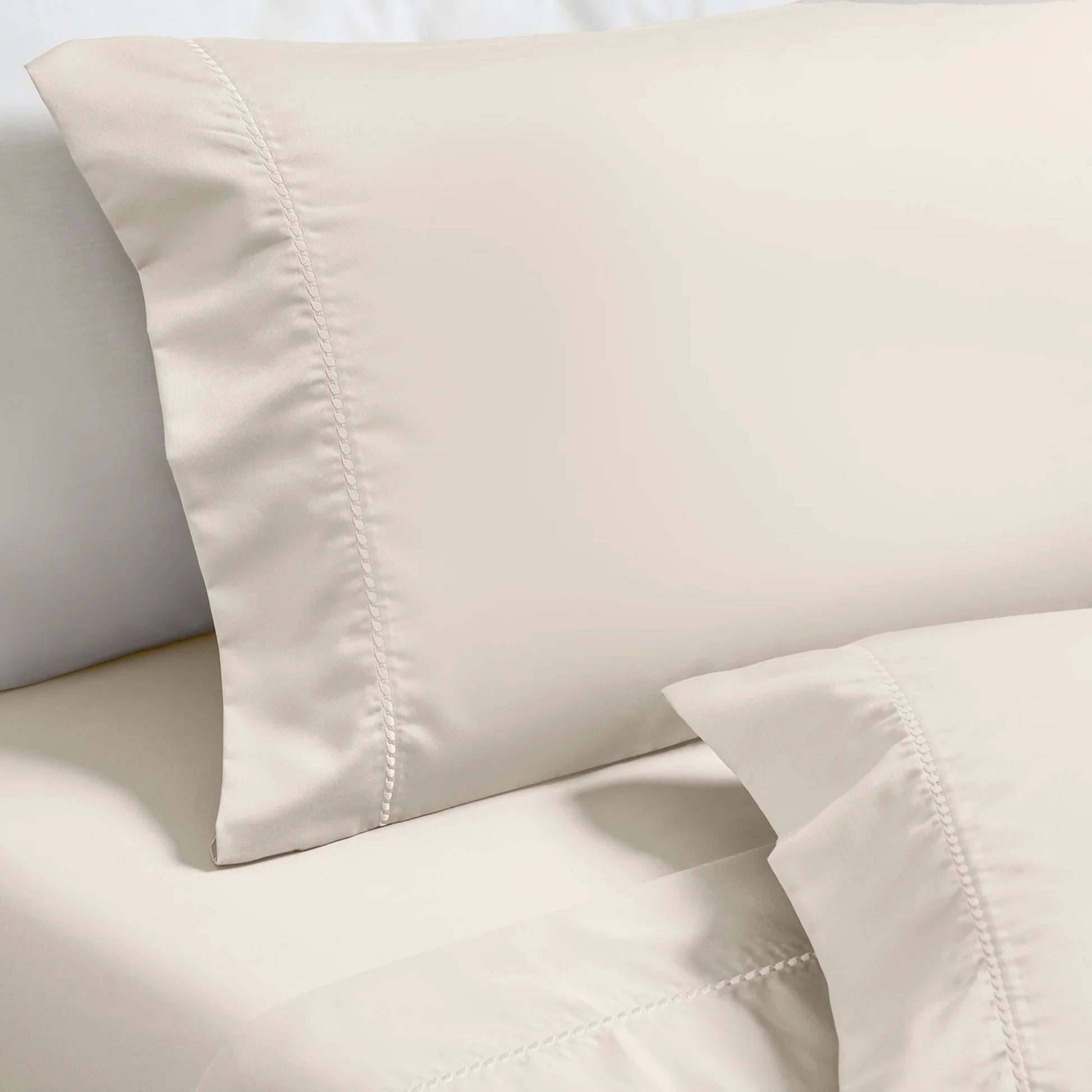 Ivory Imperia embroidered hem pillowcase set close-up detail.