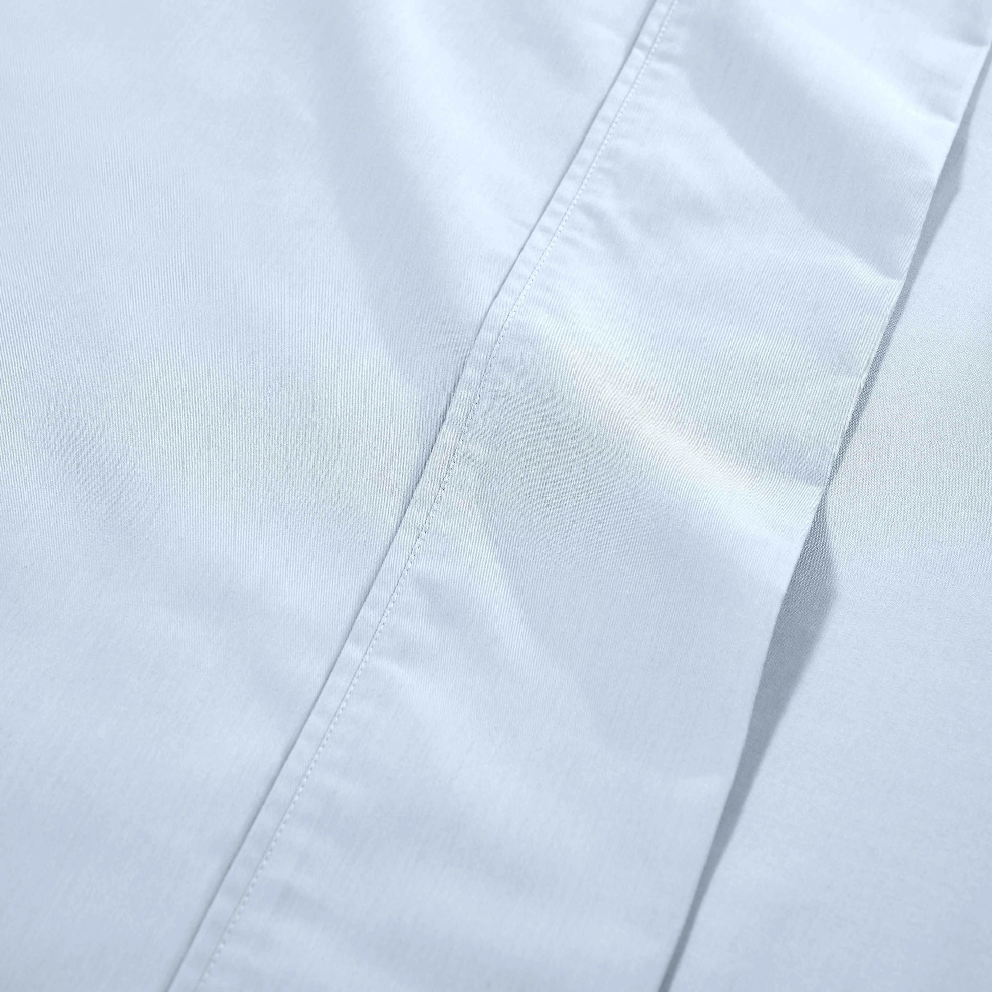 Light blue 1000 Thread Count Cotton Blend Sheets Set solid deep pocket hemline and stitching close-up fabric texture
