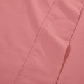 Macro view of solid blush pink bed sheet fabric highlighting the soft matte finish of the material