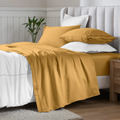 Maple Sugar Egyptian Cotton Sateen Sheet Set styled on a modern bed with white accents