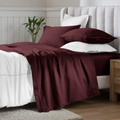 Plum Red Egyptian Cotton Sateen Sheet Set styled on a modern bed with white accents