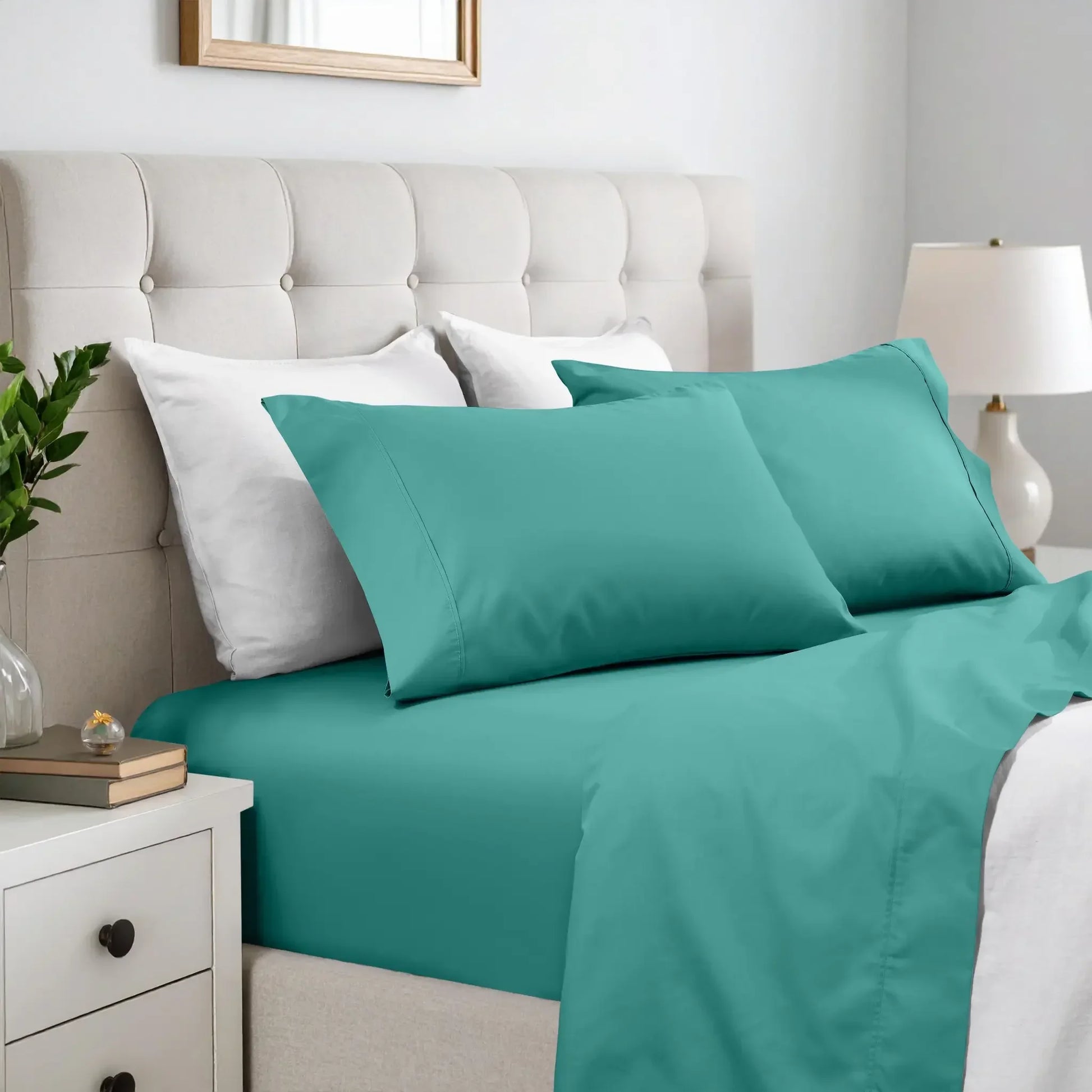 Solid teal deep pocket bed sheets and matching pillowcases with a tufted cream headboard