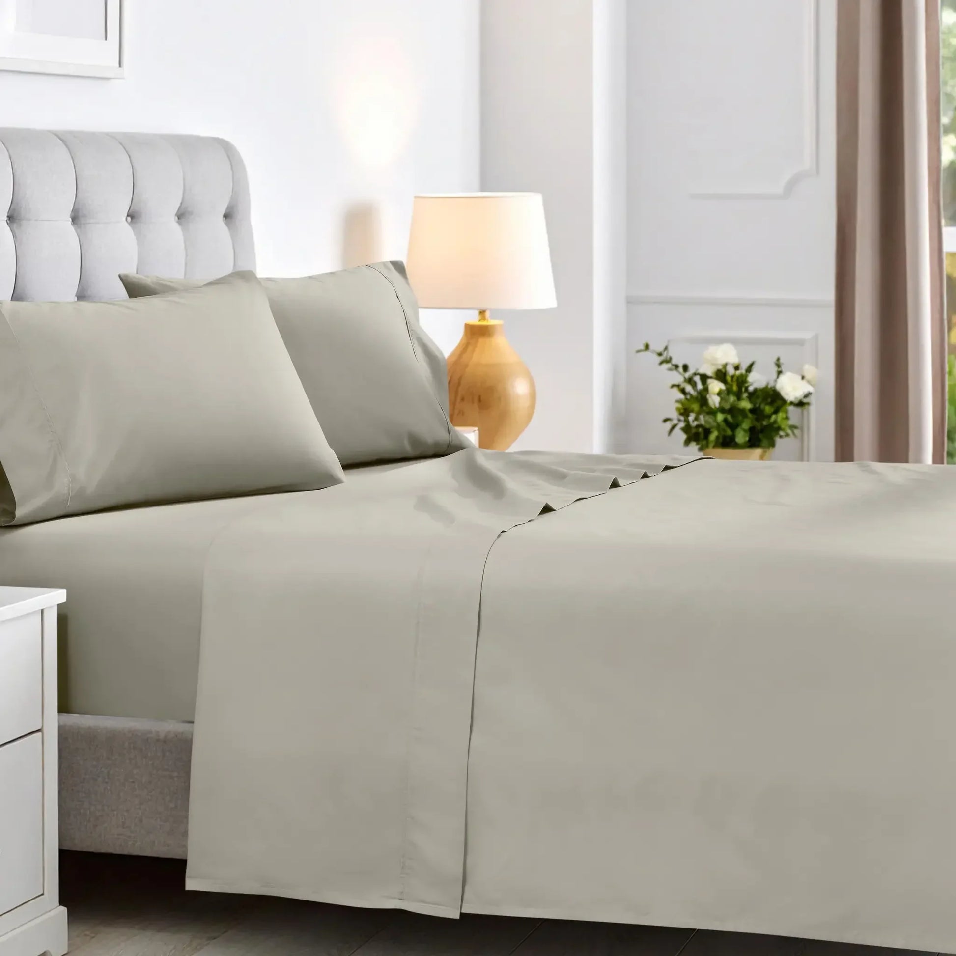 Stone gray 600 thread count cotton blend bed sheet set neatly spread across a mattress.