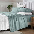 Teal blue 650 thread count Egyptian cotton sateen sheets arranged on a modern bed with coordinating pillows.