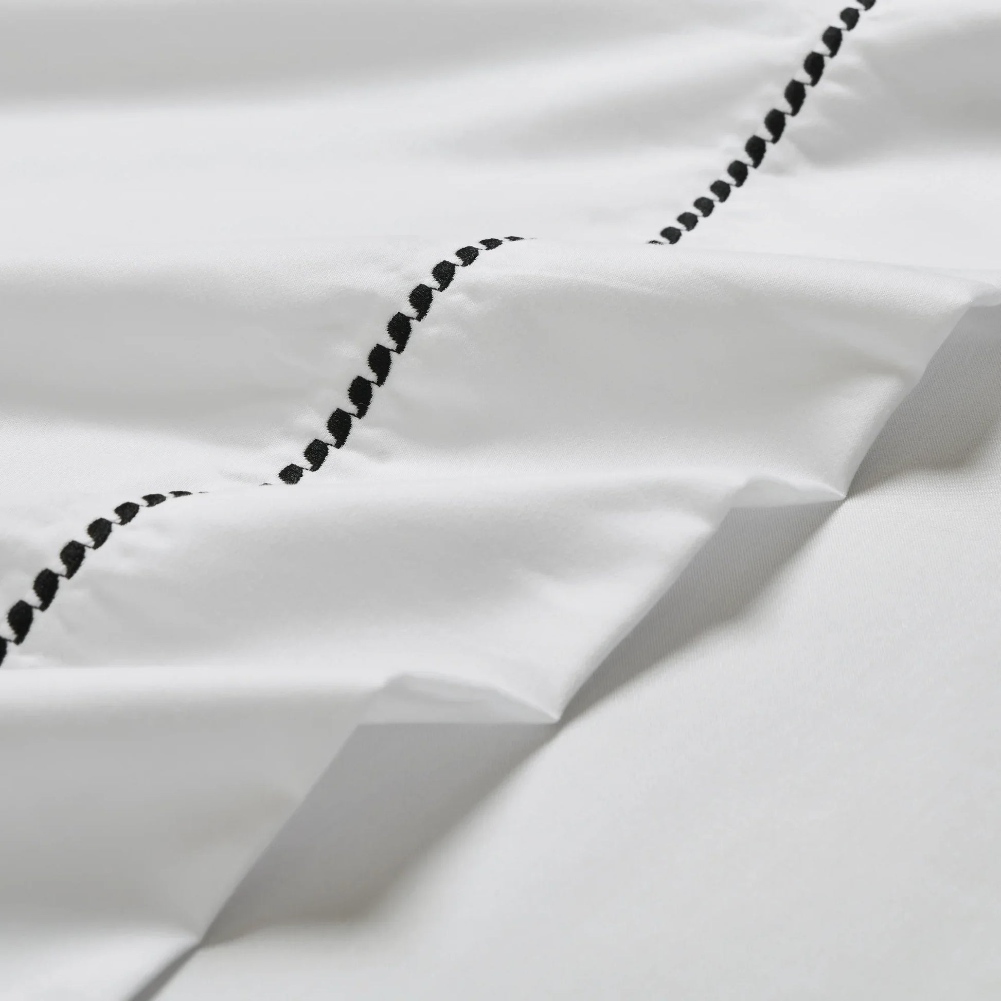 White/Black 600 Thread Count Cotton Blend Bed Sheet Set Imperia embroidery detail close-up texture.